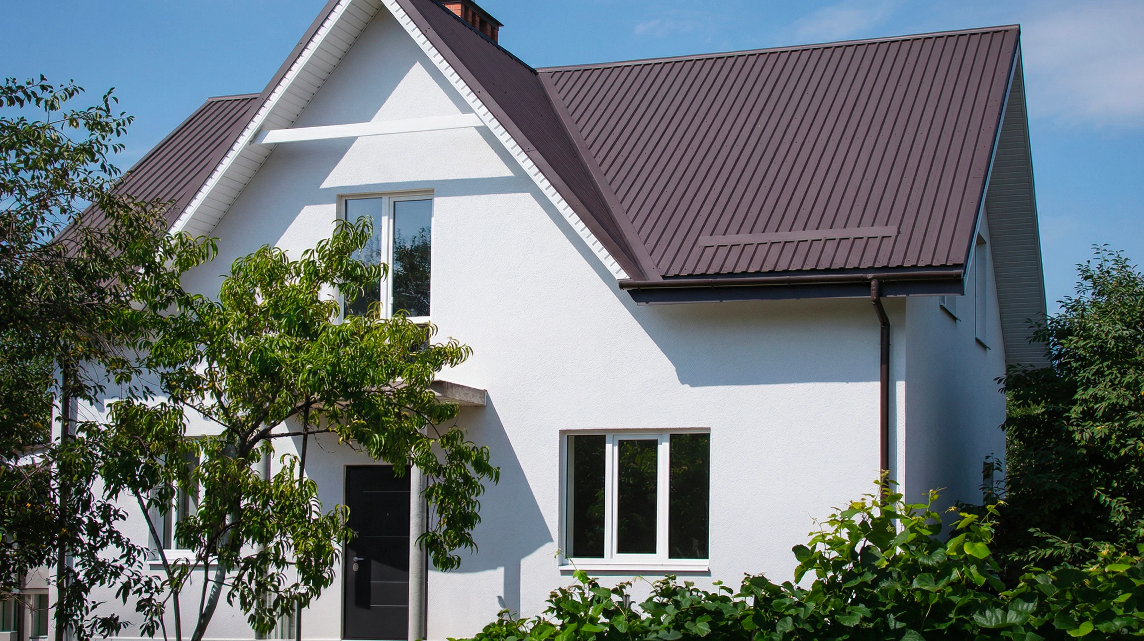 Ouvrier appliquant un enduit de façade texturé sur mur extérieur avec spatule professionnelle