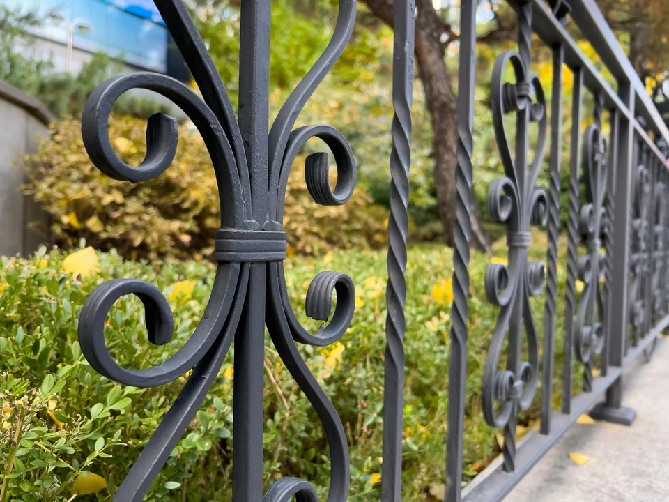 Une nouvelle clôture en bois avec des piliers en pierre finie par des pierres décoratives