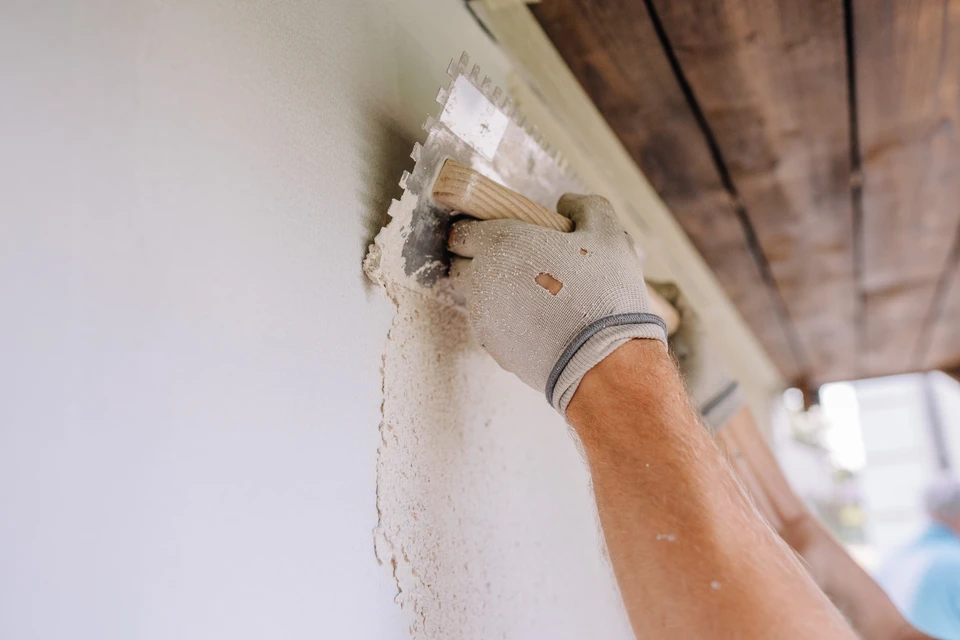 Gros plan sur un mur de briques rouges avec des joints de ciment blanc, montrant une texture rugueuse et un motif de construction rustique