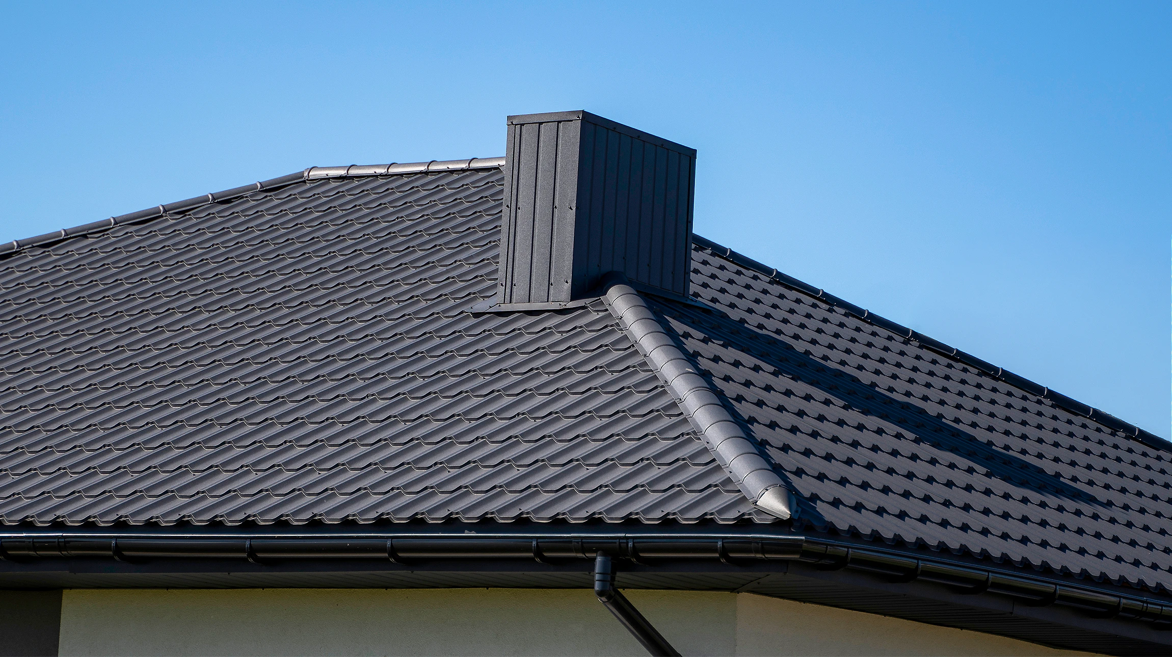 Homme sur l'échelle nettoyant la mousse et la saleté d'un toit de bâtiment - sa main dans des gants désordonnés - vue du toit